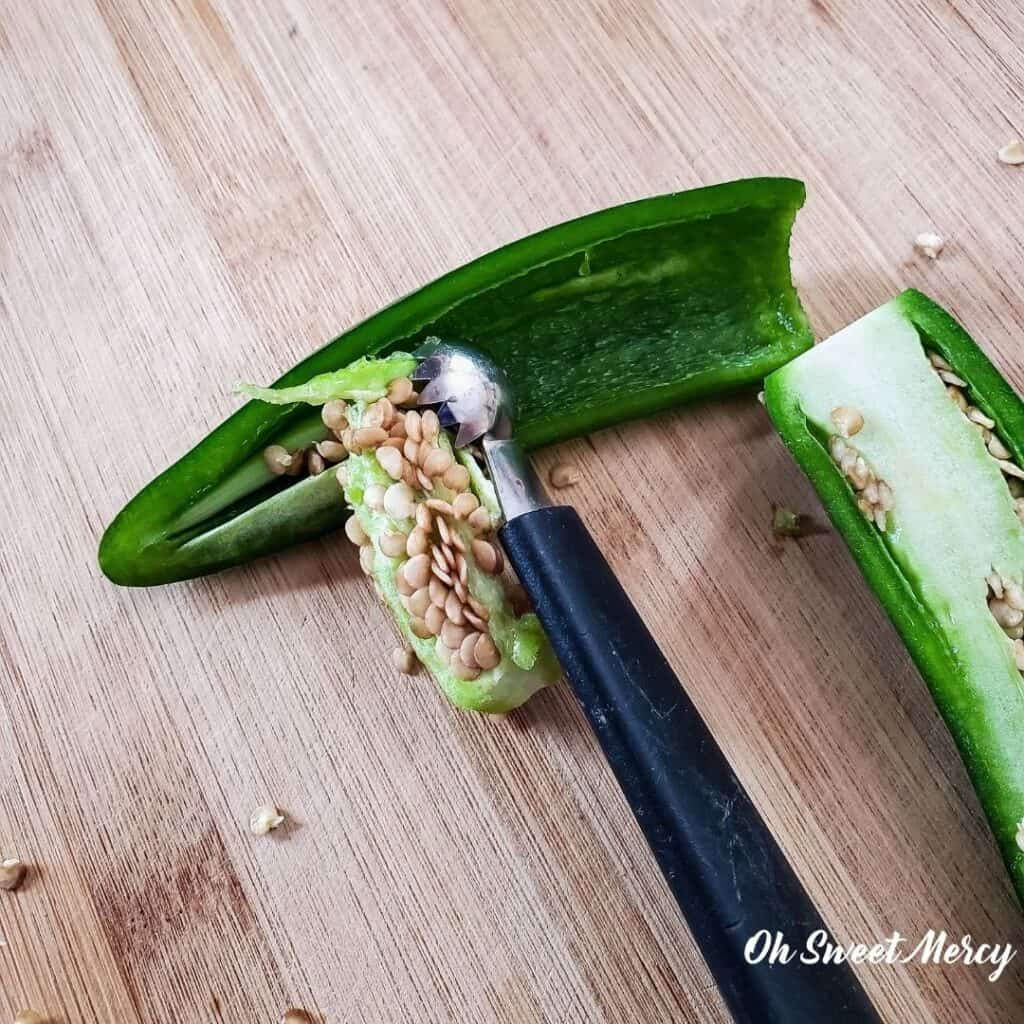 Using a strawberry huller to clean the seeds and membranes out of jalapeno peppers.