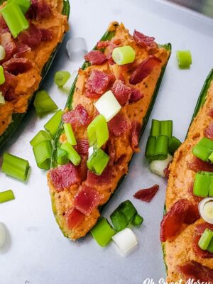 3 stuffed jalapenos on a baking sheet