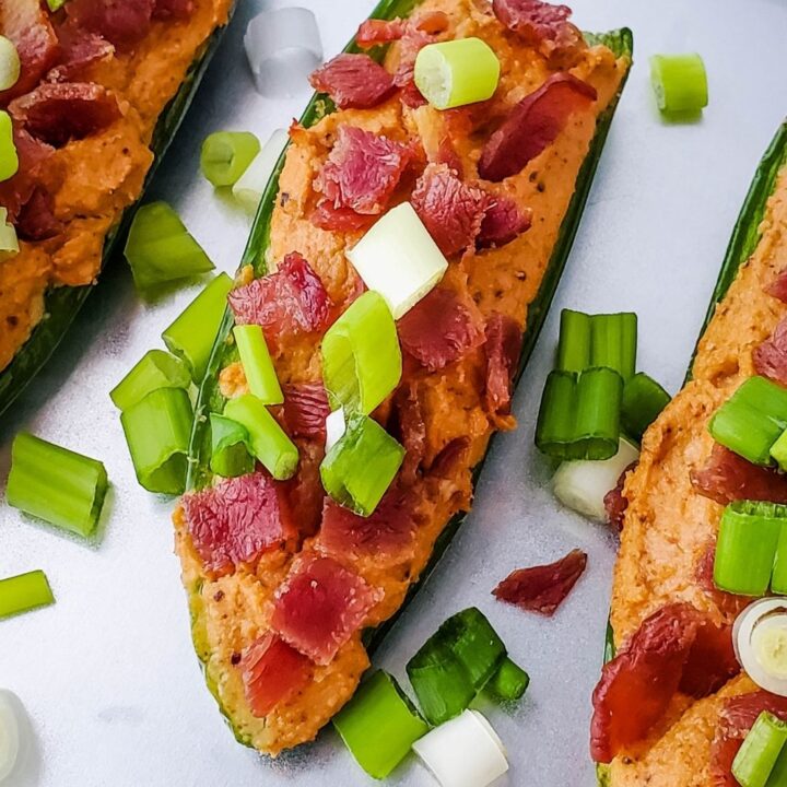 3 stuffed jalapenos on a baking sheet