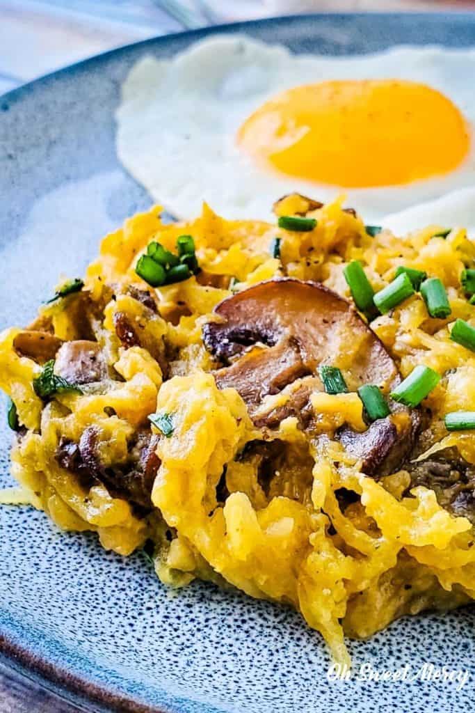 Buttery Garlic Mushroom and Chive Spaghetti Squash on a plate with a fried egg