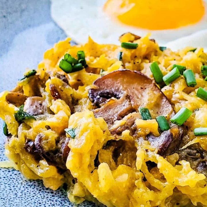 Buttery Garlic Mushroom and Chive Spaghetti Squash on a plate with a fried egg