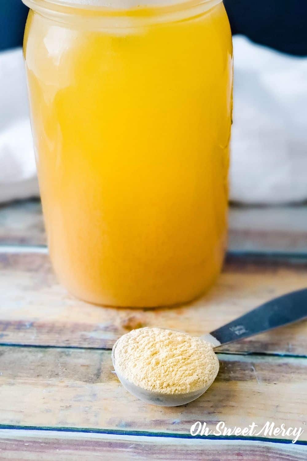 Mason jar of baobab water and measuring spoon with baobab powder