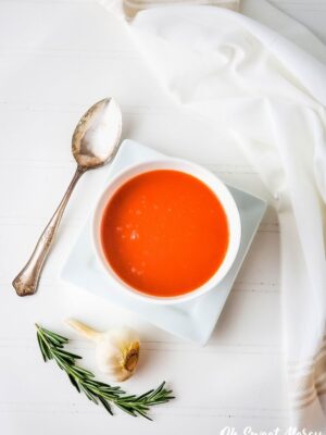 Overhead shot of garlic rosemary tomato soup in a white bowl