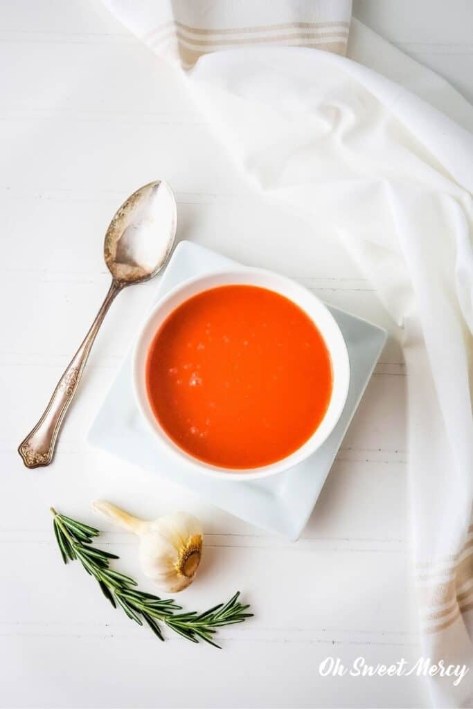 Overhead shot of garlic rosemary tomato soup in a white bowl