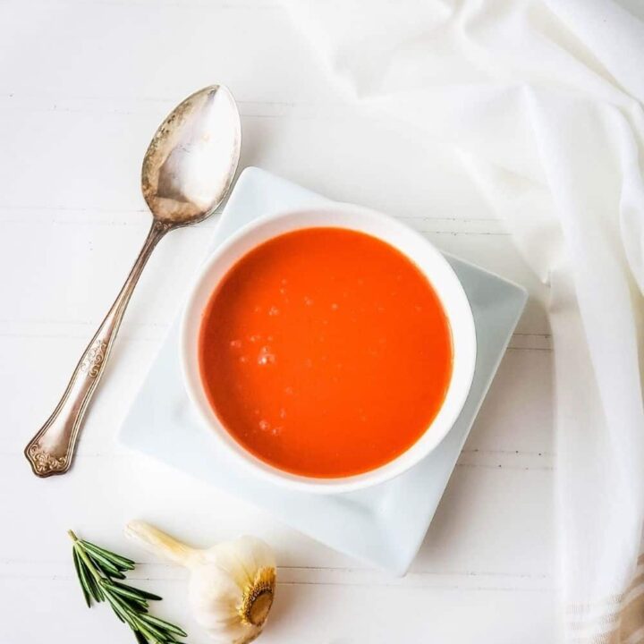 Overhead shot of garlic rosemary tomato soup in a white bowl