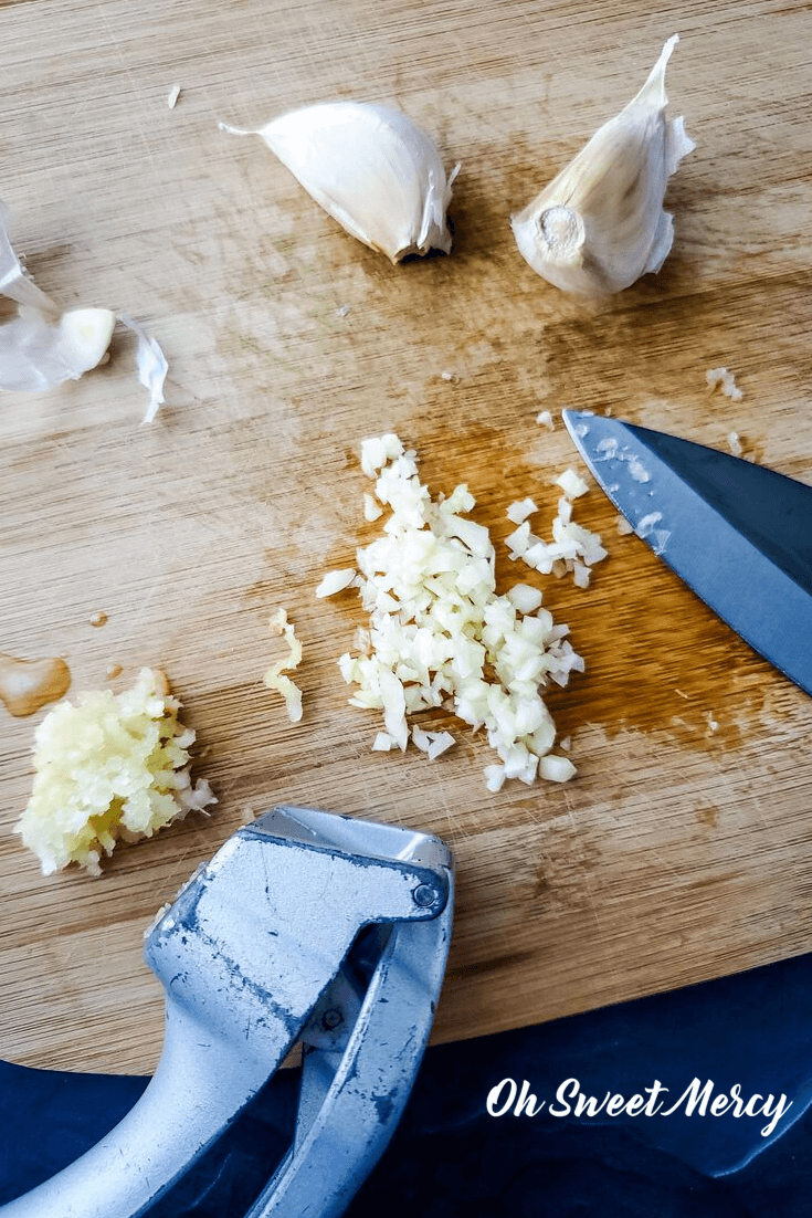 Minced and pressed garlic on a cutting board