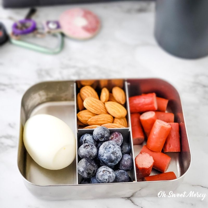 High protein snack box - hard cooked egg, almonds, turkey snack sticks, fresh berries.