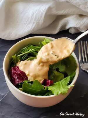 LOW CARB THOUSAND ISLAND DRESSING BEING POURED ON A SALAD