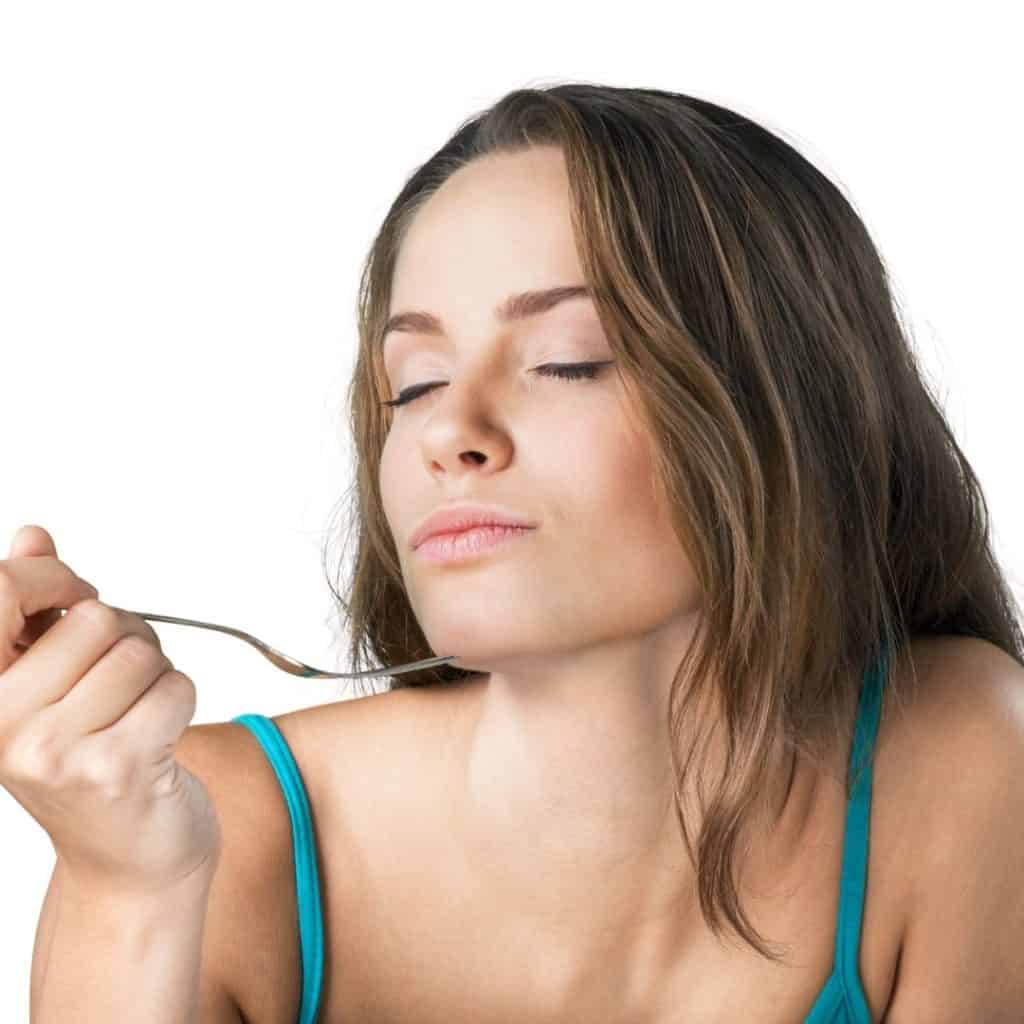 Woman eating with fork looking happy