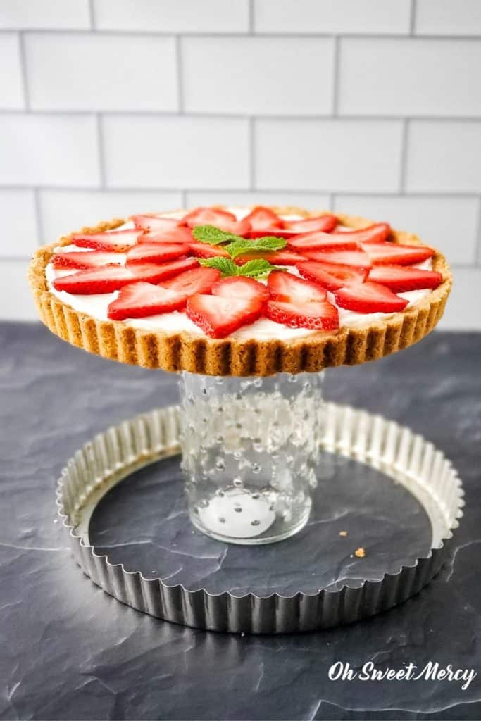 How to remove the ring from a tart pan: set pan on top of mason jar or drinking glass and gently push down on ring until it drops off. 