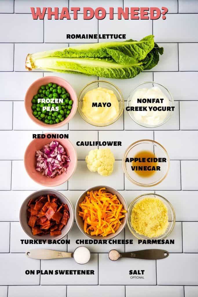 Low Carb 7 Layer Salad Ingredients: romaine lettuce, peas, red onion, turkey bacon, cheddar cheese, cauliflower, mayo, nonfat Greek yogurt, apple cider vinegar, parmesan cheese, sweetener, optional salt