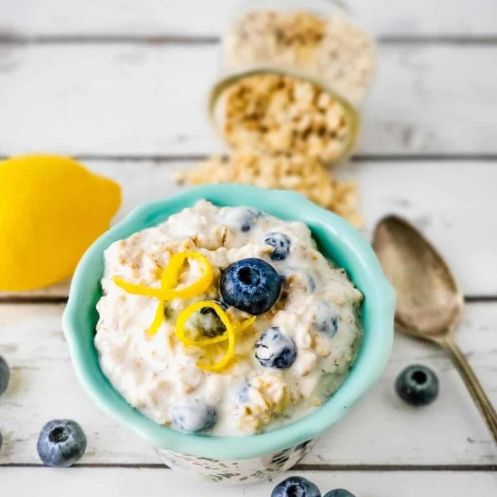 Bowl of overnight oats garnished with blueberry and lemon zest.