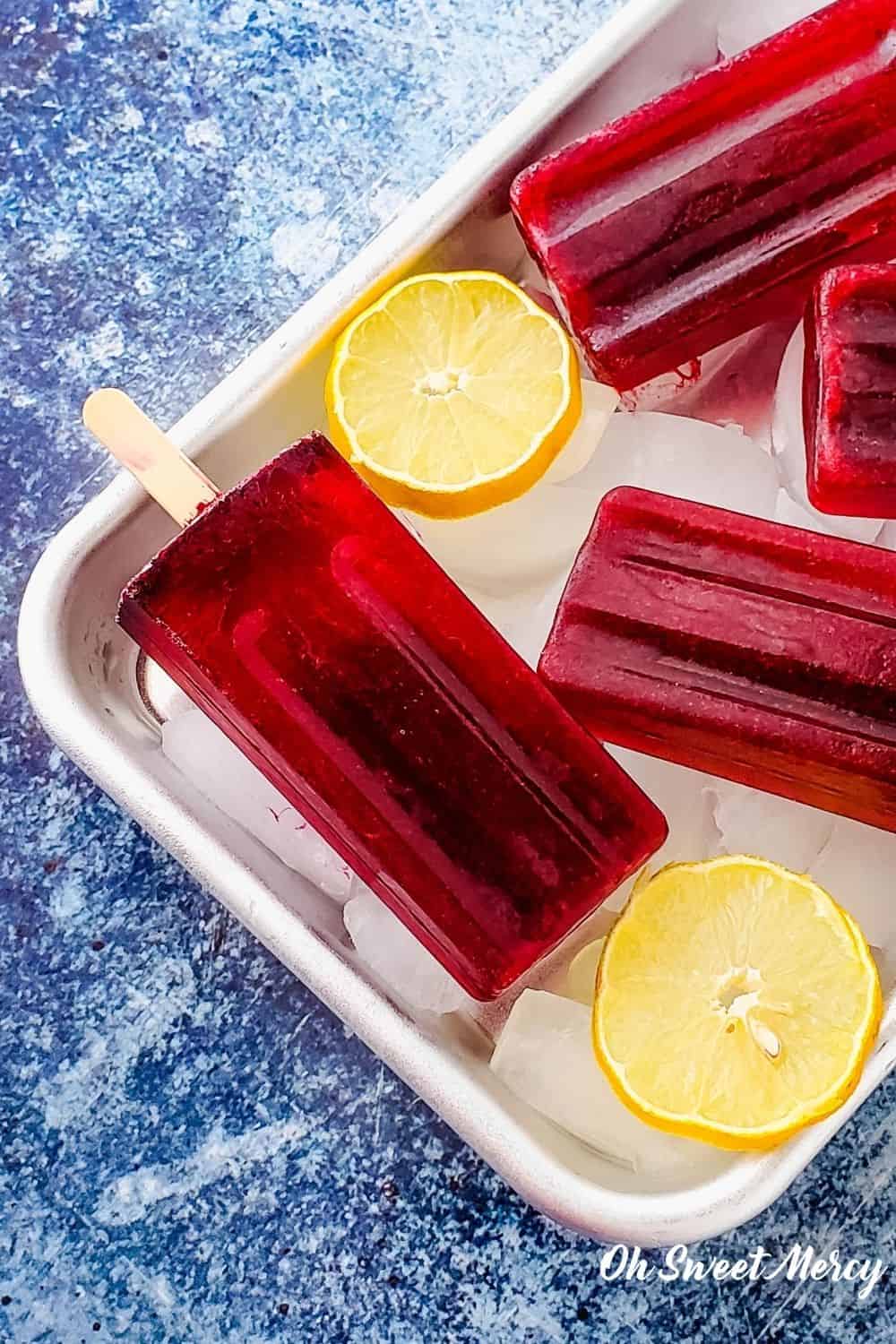 Refreshing, healthy, and gorgeously red (without artificial dyes) these simple Lemon Hibiscus Popsicles are sugar free and a fantastic THM FP treat. With zero fuel, enjoy these any time, with any THM fuel style. #sugarfree #hibiscus #popsicles #thm #fuelpull @ohsweetmercy