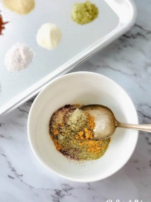 Mixing bulk breakfast sausage seasoning ingredients in a bowl.