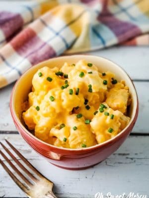Bowl of low carb cheesy cauliflower with fresh chives