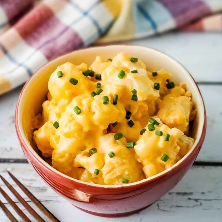 Bowl of low carb cheesy cauliflower with fresh chives