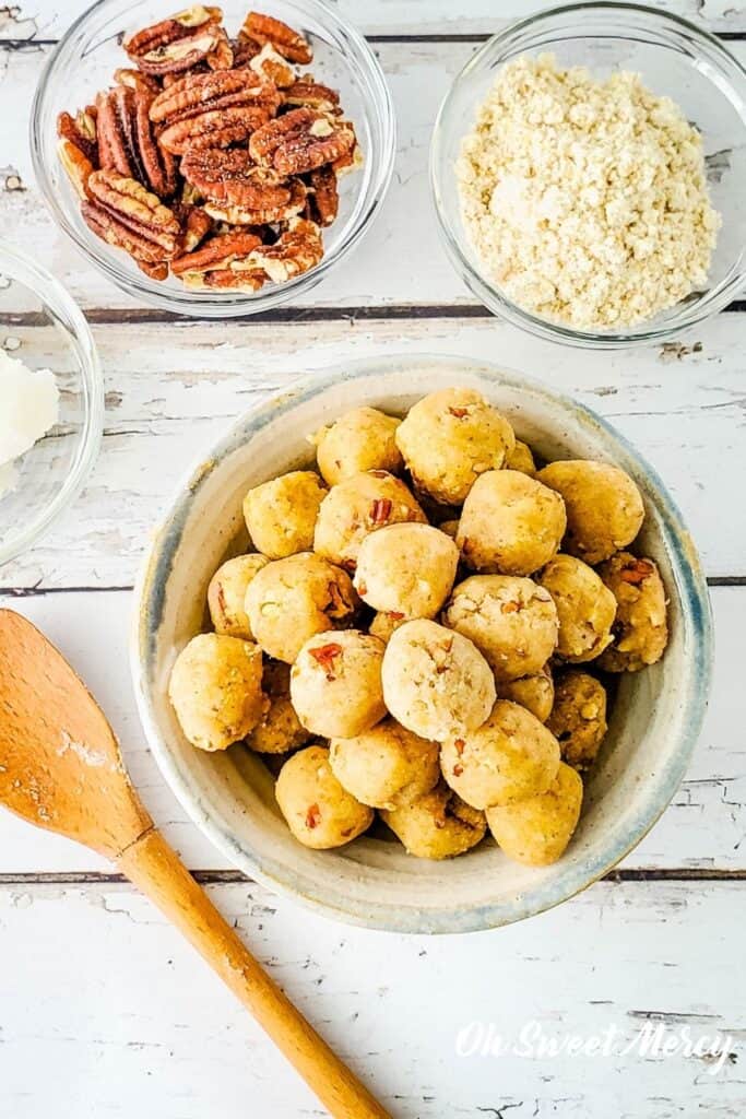 Overhead shot of bowl of butter pecan protein bites with some ingredients