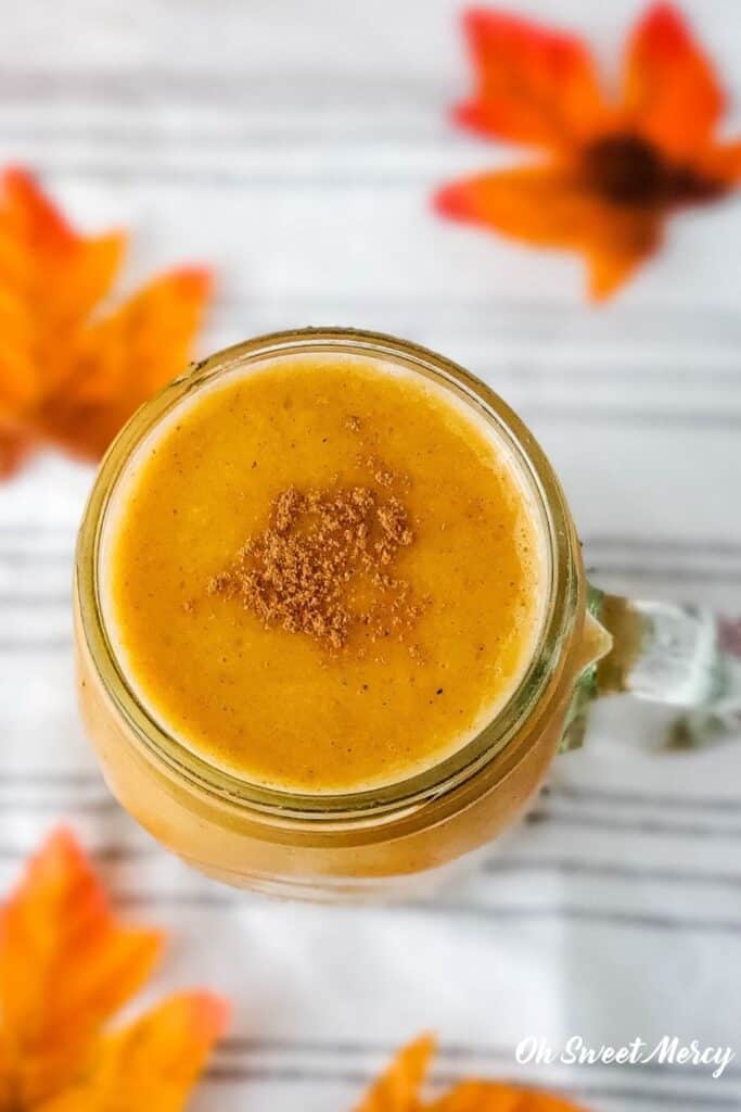 Overhead shot of shake in mug with autumn leaves in background