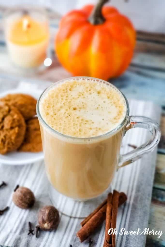 Beverage in clear glass mug with plate of cookies