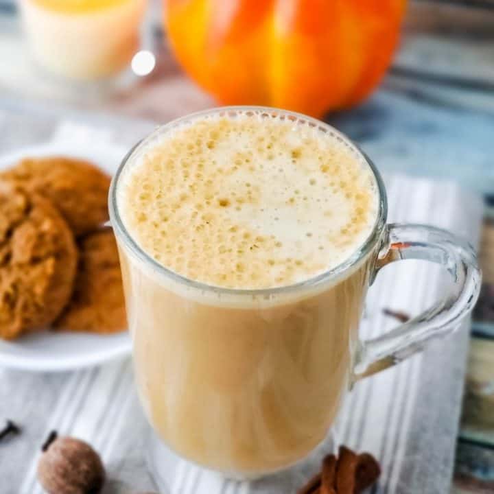 Beverage in clear glass mug with plate of cookies