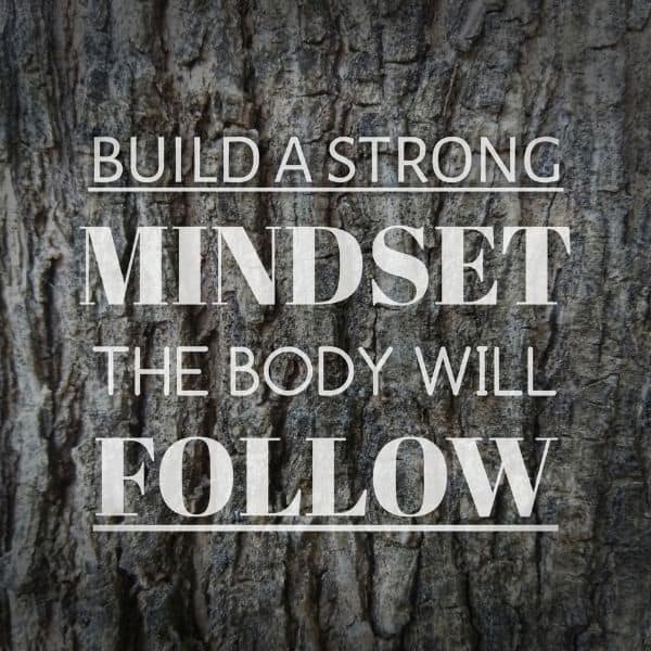 Quote: "Build a strong mindset the body will follow" on a tree bark background