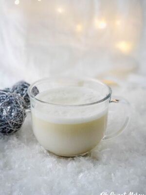 Clear glass mug of frothy dairy free creamy peppermint white hot chocolate