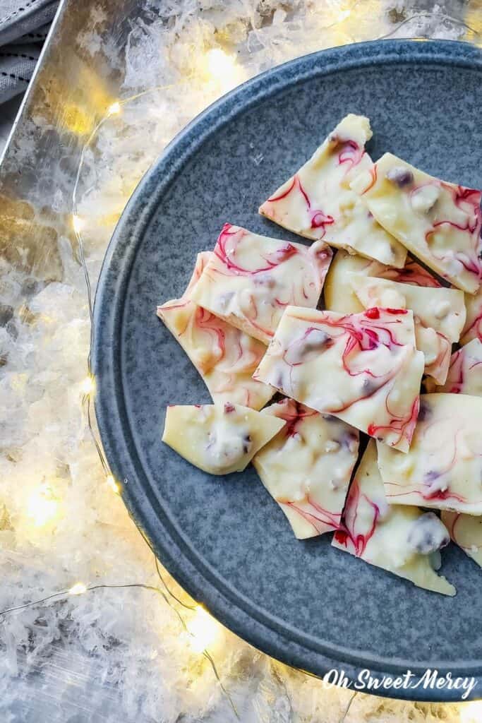 Plate of peppermint bark surrounded by snow and white lights