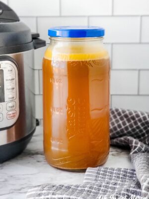 Jar of smoked turkey broth beside an Instant Pot