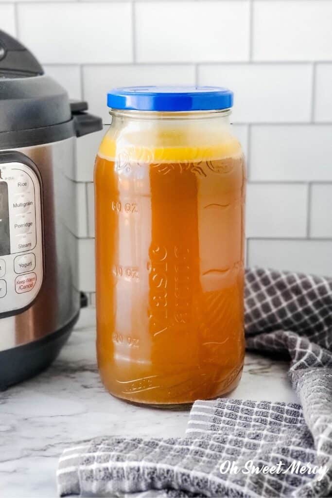 Jar of smoked turkey broth beside an Instant Pot