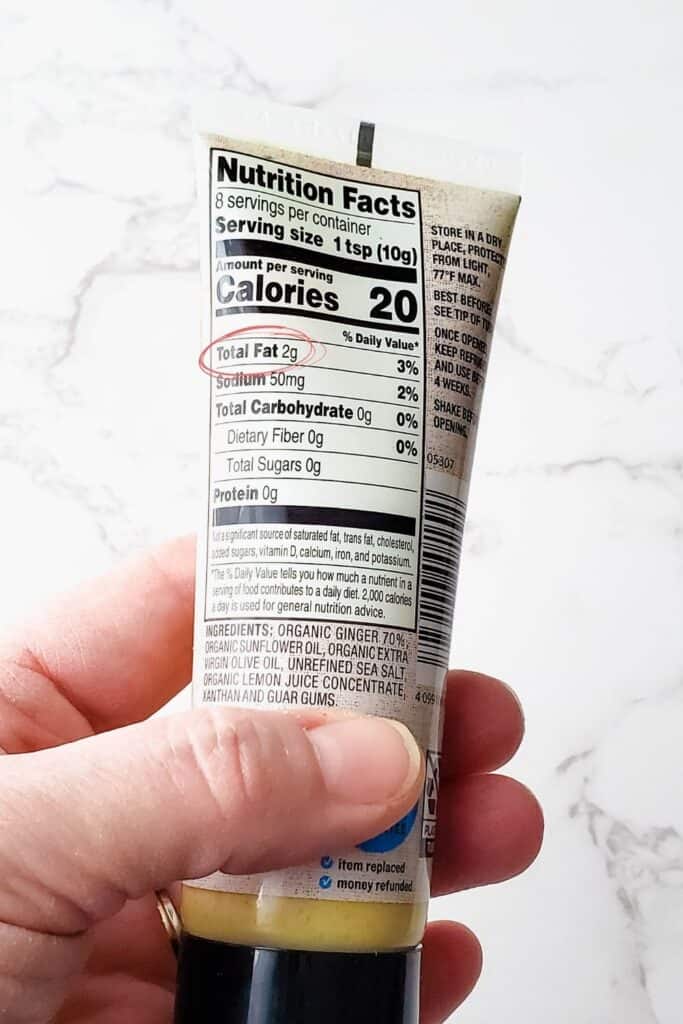 Tube of ginger paste with ingredients and nutrition info showing 1 tsp has 2 grams of fat and sunflower and olive oil in the paste.