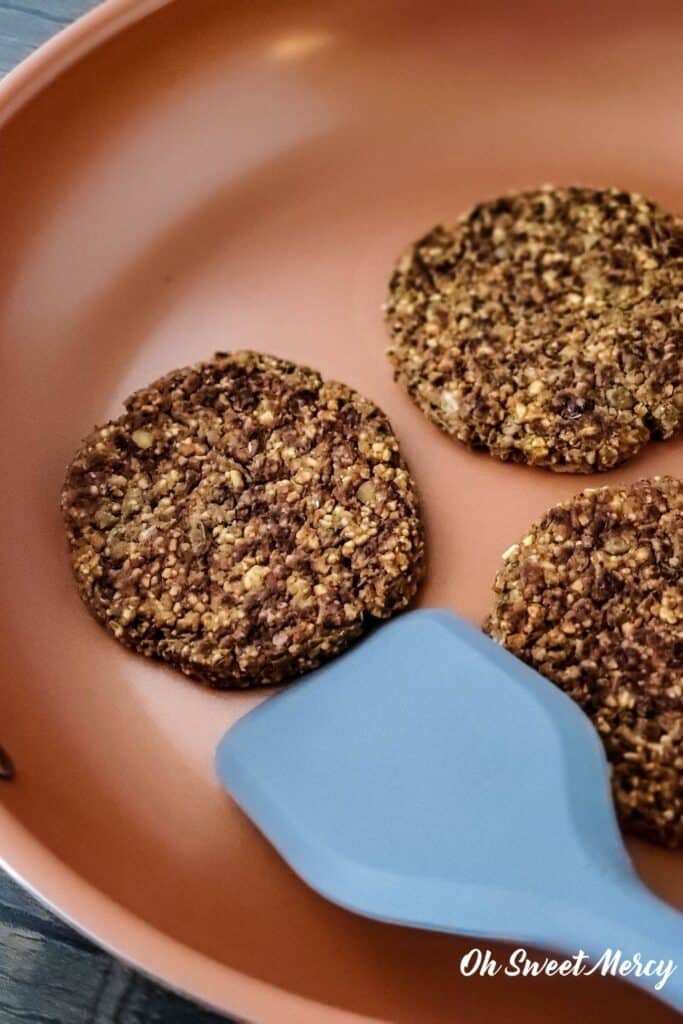 cooking lentil burgers in copper ceramic skillet