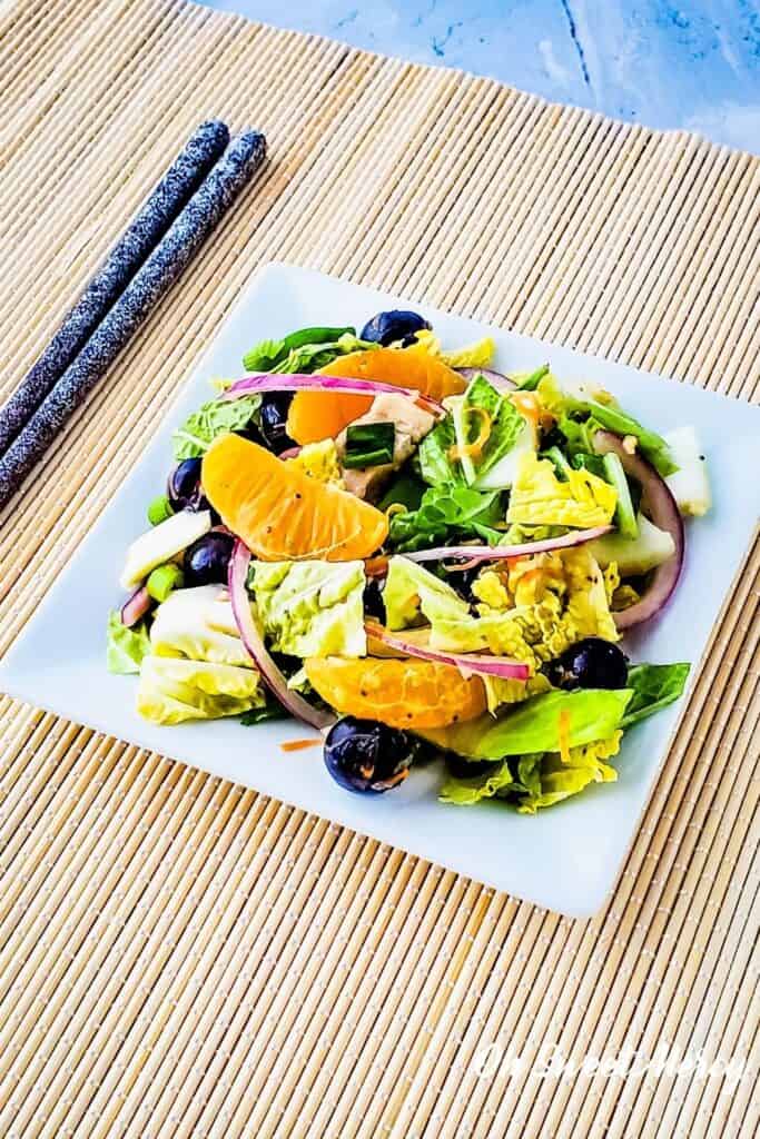 square white plate with mandarin blueberry napa cabbage salad