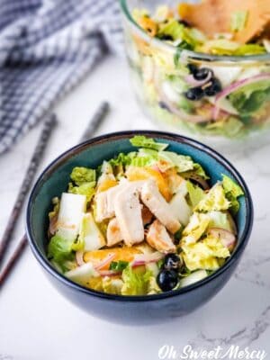 Close up of bowl of salad with chicken.