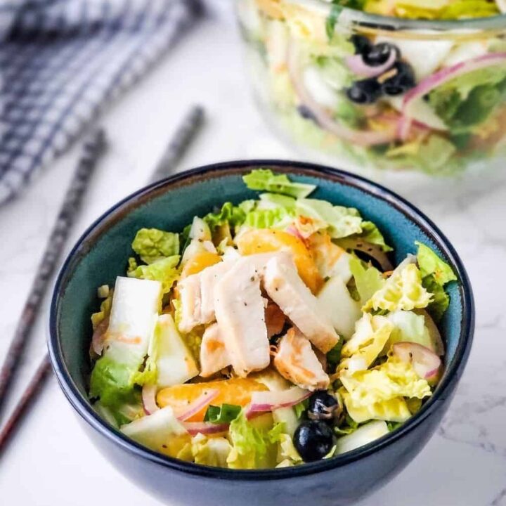 Close up of bowl of salad with chicken.