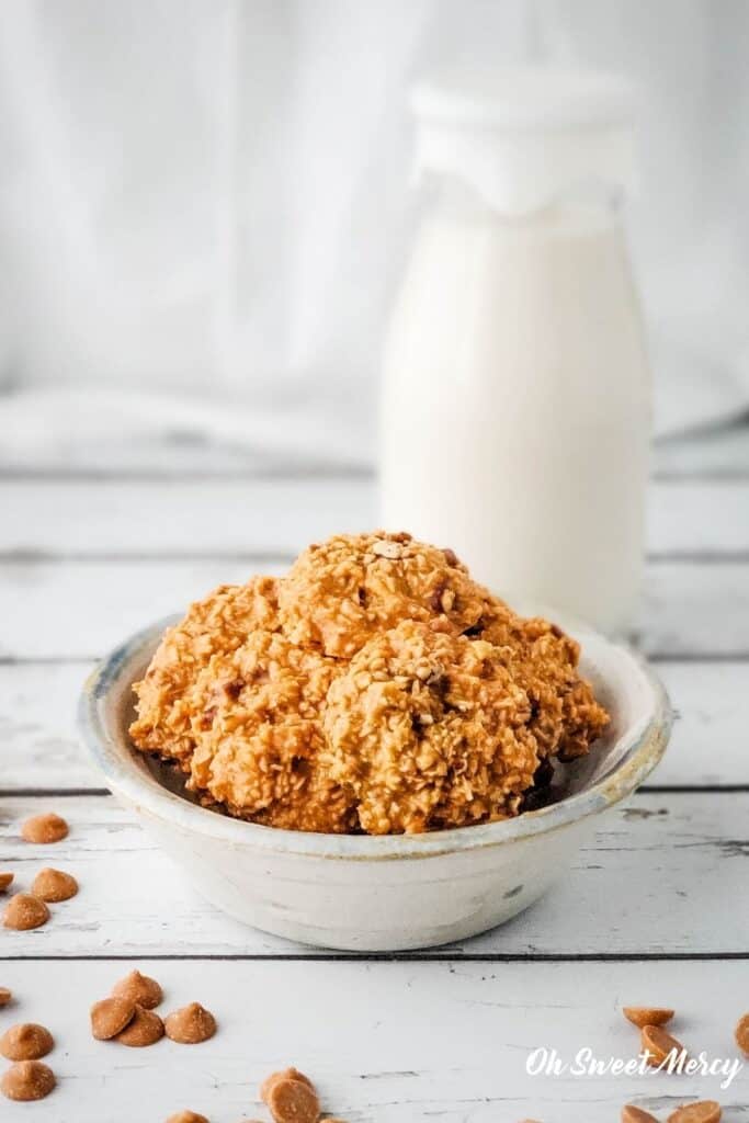 bowl with cookies in it with glass of almond milk behind