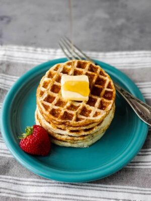 Pouring syrup on a stack of mini waffles