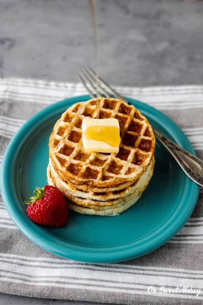 Pouring syrup on a stack of mini waffles