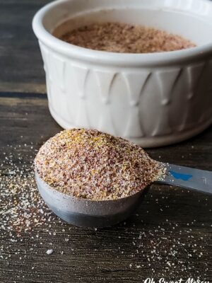 Heaping teaspoon of seasoning blend in front of white bowl.