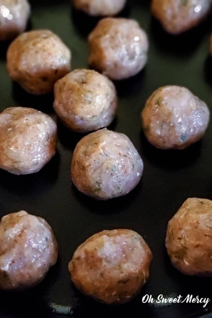 Prepared meatballs in cast iron skillet ready for the oven