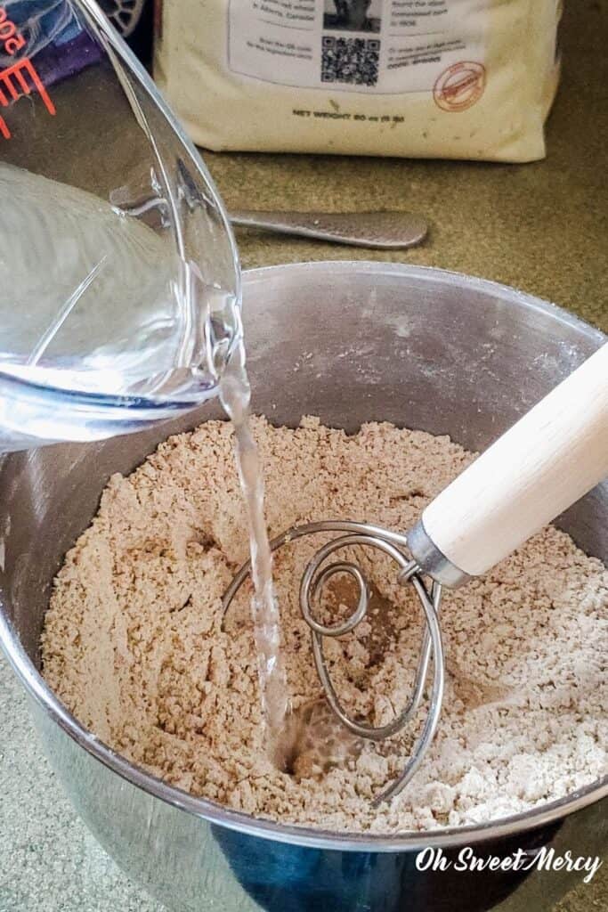 Pouring water into bowl of flour