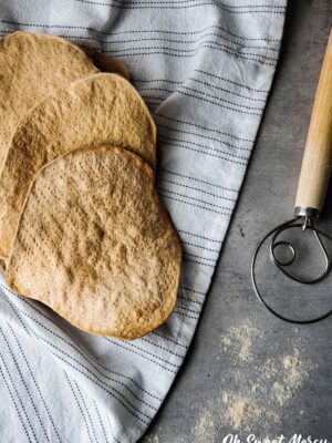 Sprouted wheat matzah on towel with dough whisk nearby