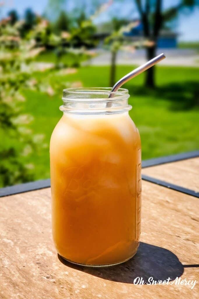 Mason jar of Creamy Coconut Oolong Iced Tea outside on a sunny day