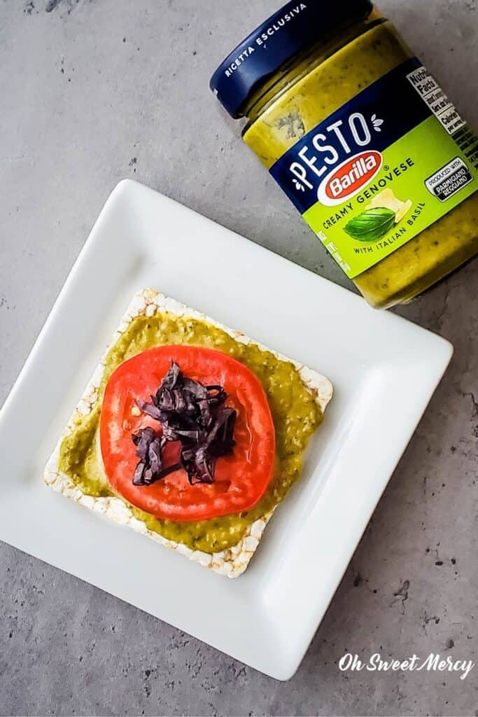 Thin rice cake spread with Barilla Creamy Genovese Pesto, topped with juicy tomato slice from my garden and purple basil.