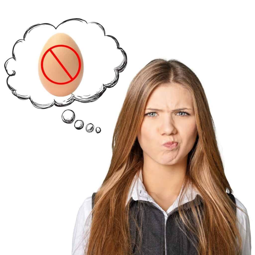 Woman with a disappointed face, thought bubble with egg with a no symbol on it