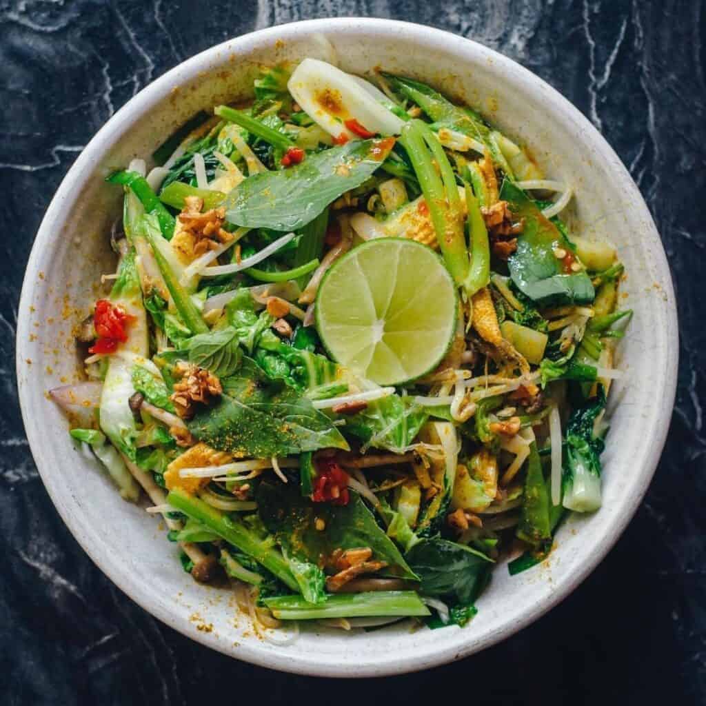 Fresh salad on white plate with dark background