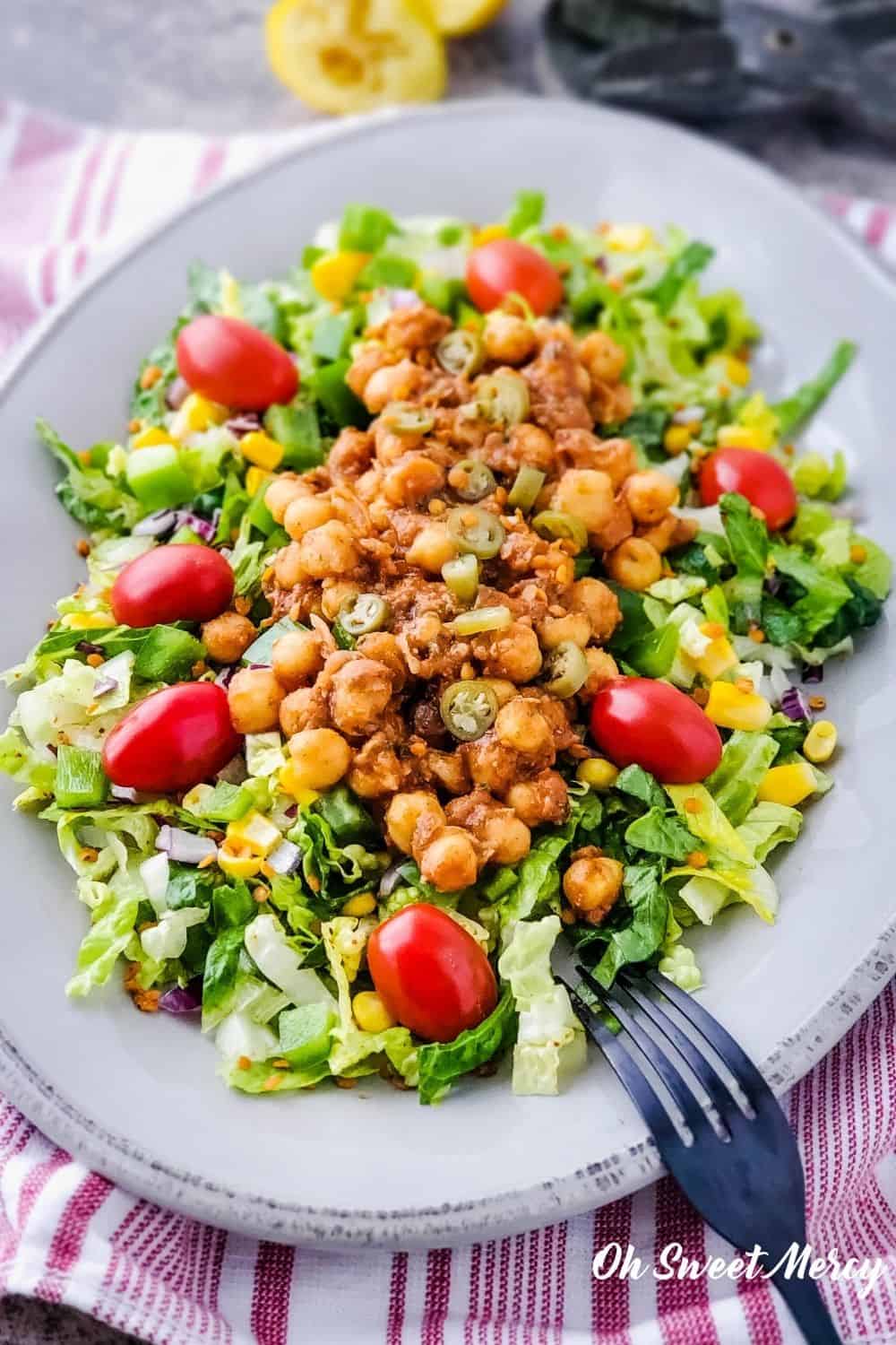 Plate of Chickpea Taco Salad on a red and white striped background.