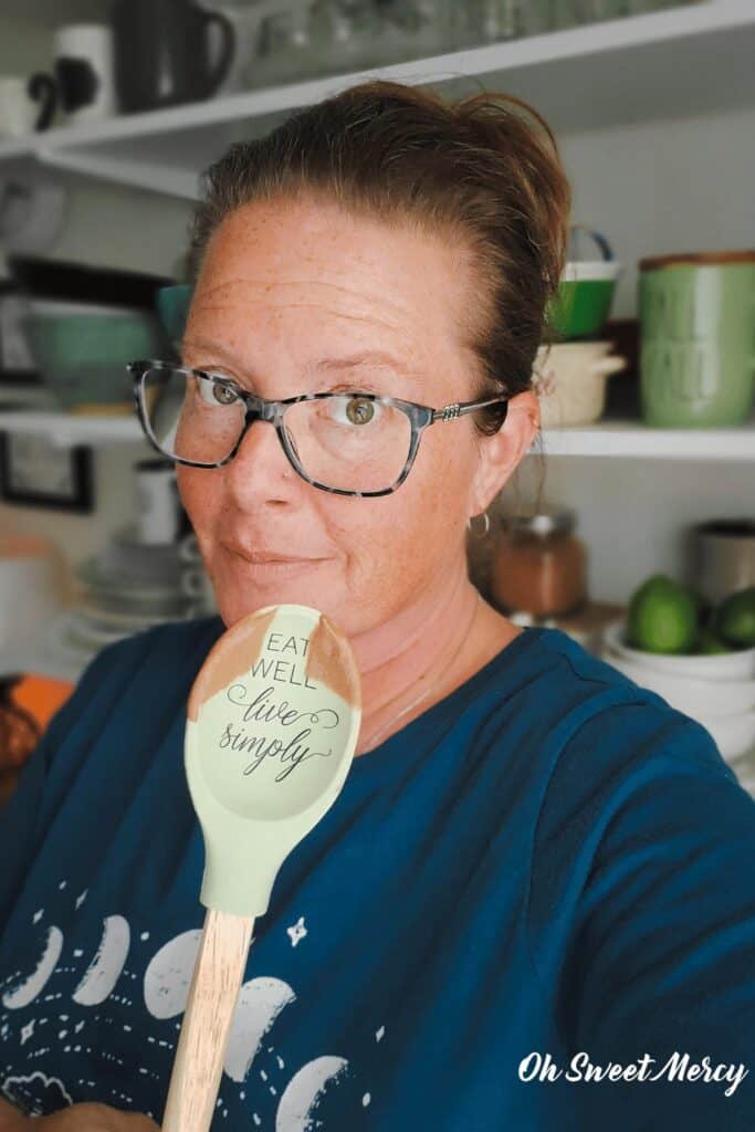 Picture of me holding a spatula that says "eat well, live simply" with a bit of chocolate pudding on it