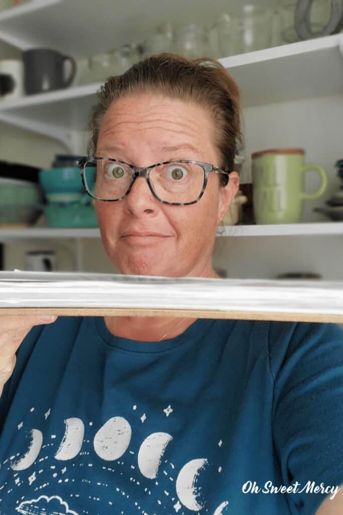 Photo of me holding my project sheet clipboard with about 1 inch of project sheets!