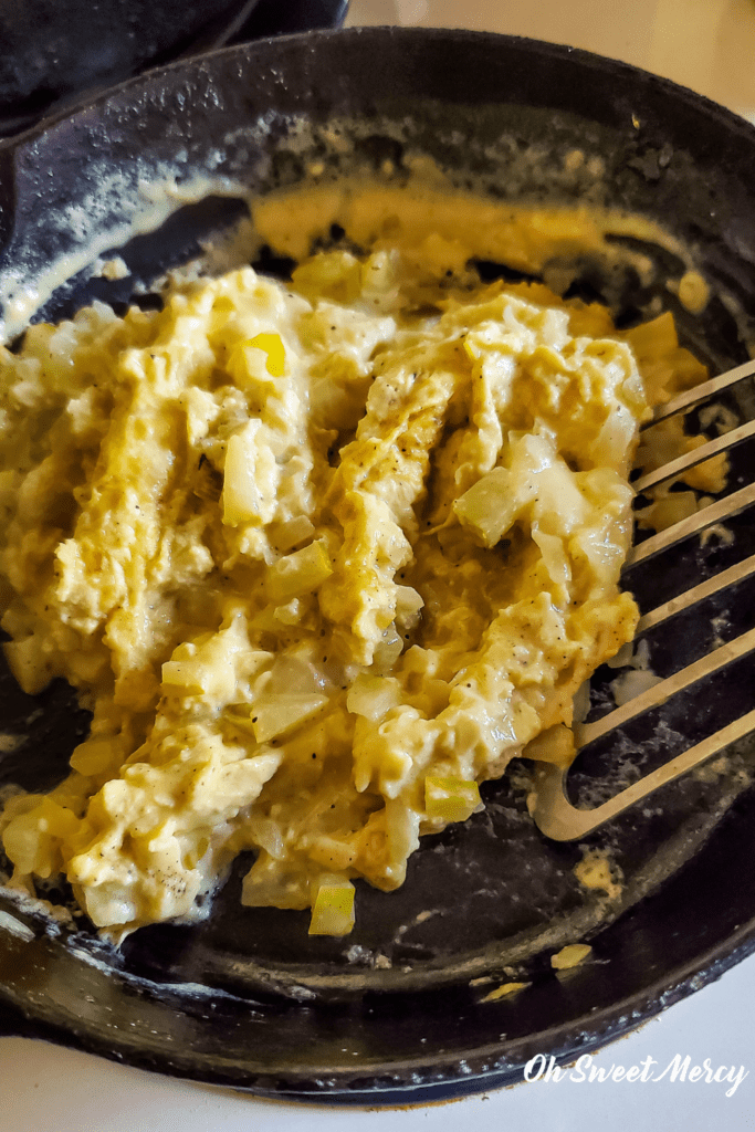 Cooking Dill Pickle Scrambled Eggs in a cast iron skillet